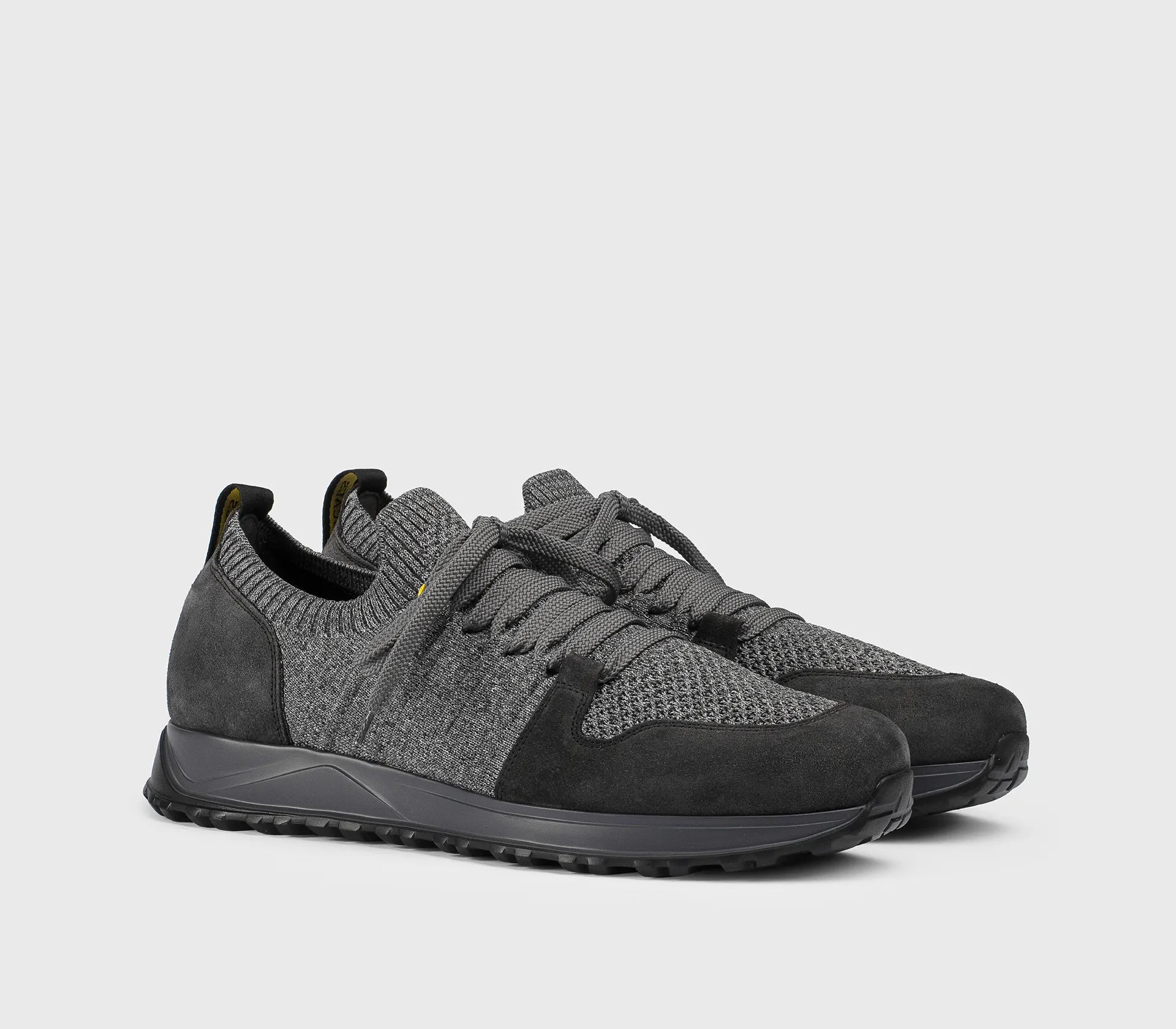 Grey mixed-material sneaker with dark grey accents.